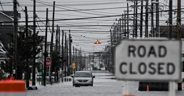 A flooded street with a "ROAD CLOSED" sign and utility poles is shown, indicating severe weather damage.