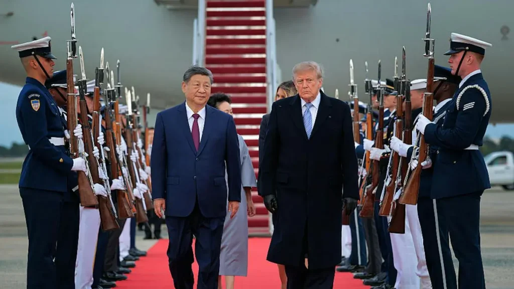 The image shows a formal arrival ceremony with two leaders walking down a red carpet flanked by uniformed guards holding rifles.