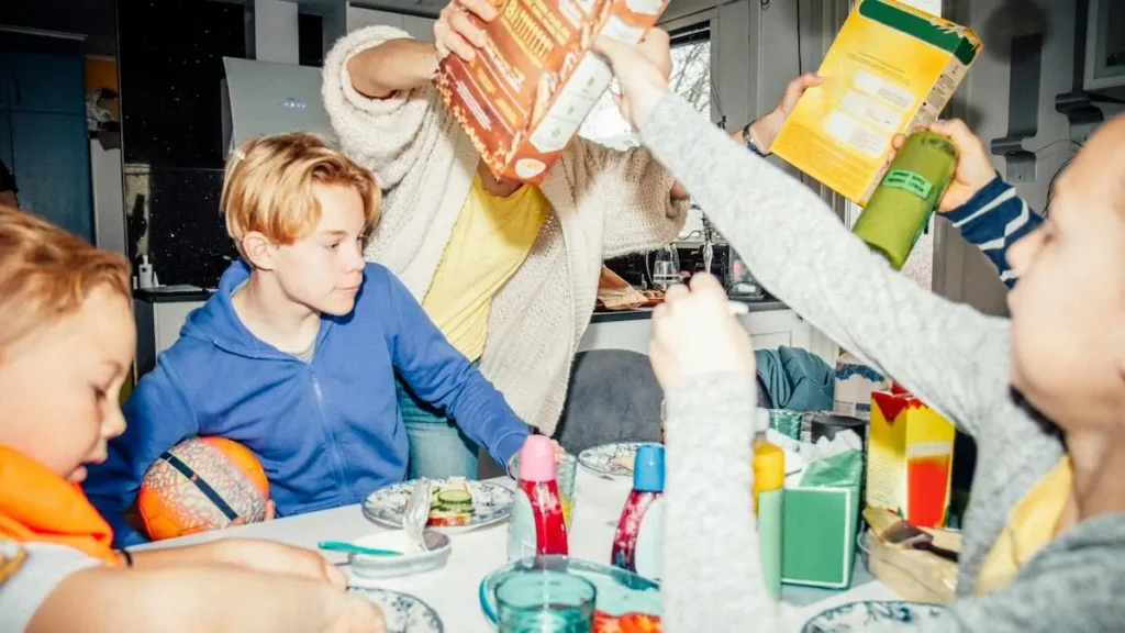 A family gathers around a table, raising their breakfast items in a toast, creating a warm and celebratory atmosphere.