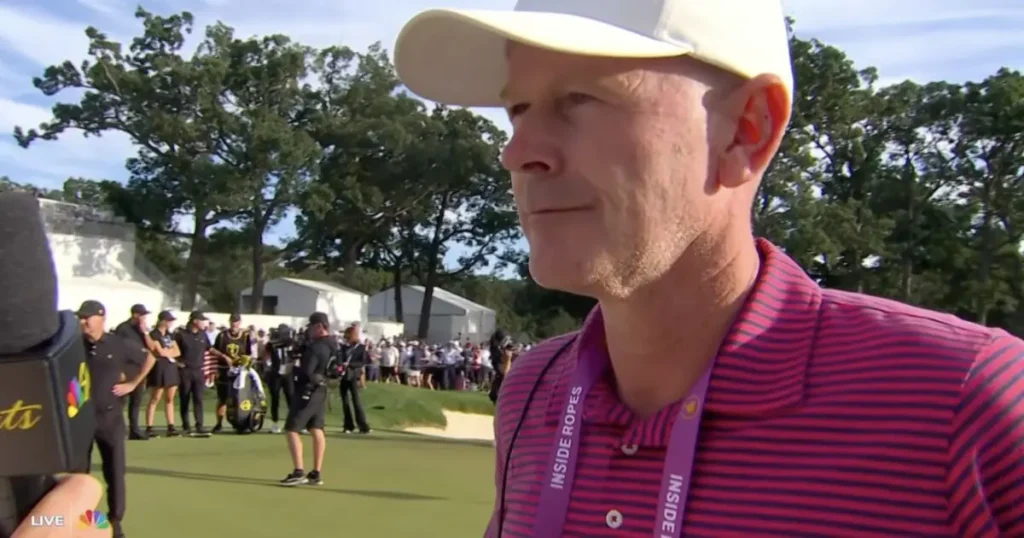 A golfer in a striped shirt and cap is being interviewed on a golf course, with spectators and staff in the background.