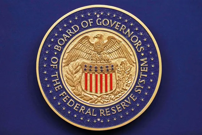 The image shows the seal of the Board of Governors of the Federal Reserve System, featuring an eagle and the U.S. shield.