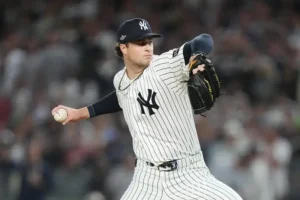 A baseball pitcher in a New York Yankees uniform is captured mid-pitch during a game.