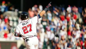 A baseball player celebrates with a high-five gesture in front of a cheering crowd.