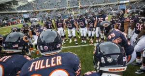 The Chicago Bears team huddles together on the field during a game.