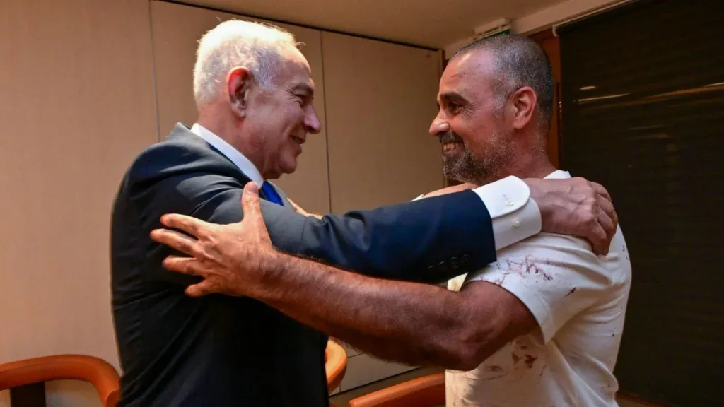 Two men are embracing warmly in a celebratory or supportive moment.