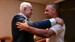 Two men are embracing warmly in a celebratory or supportive moment.