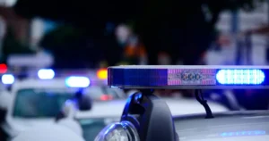The image shows a police car with flashing blue lights, indicating an emergency or active scene.