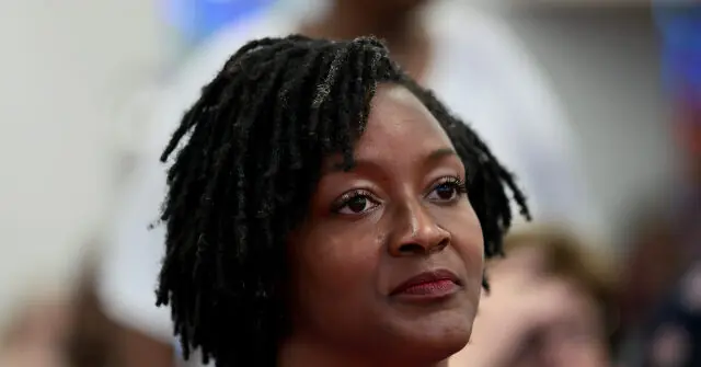 The image shows a person with dreadlocks, looking off to the side with a thoughtful expression.