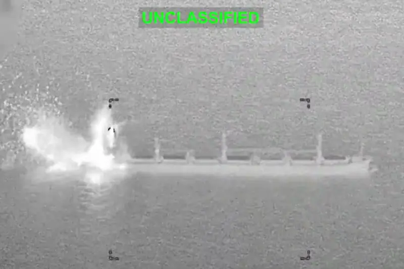 The image shows a military strike on a ship, with visible smoke and fire indicating an explosion or impact.