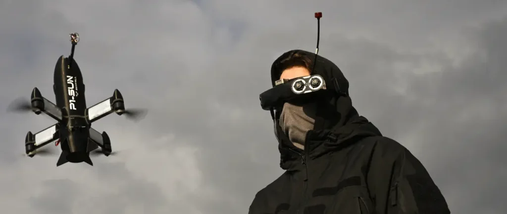 A person wearing a VR headset and a winter jacket stands under a cloudy sky, with a drone flying nearby.
