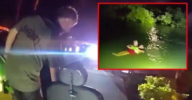 The image shows a nighttime rescue operation where a person is being pulled from the water by emergency responders.