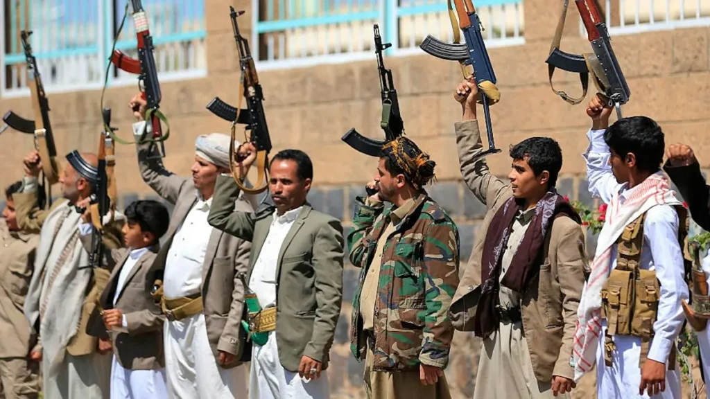 A group of individuals, some in military attire, raise their weapons in a public demonstration.