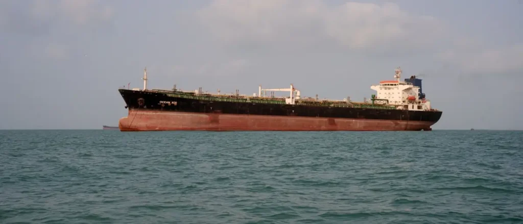 The image shows a large tanker ship named "Ocean Koi" sailing on calm waters.