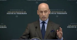 A man in a suit is speaking at a podium during a ministerial on the resurgence of political terrorism.