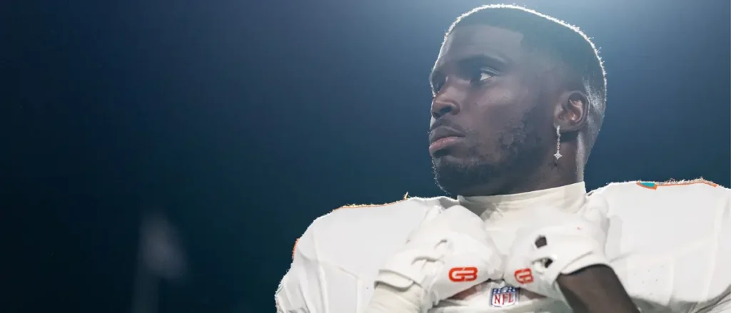 The image shows a football player in a white uniform with the NFL logo, looking off to the side with a focused expression.