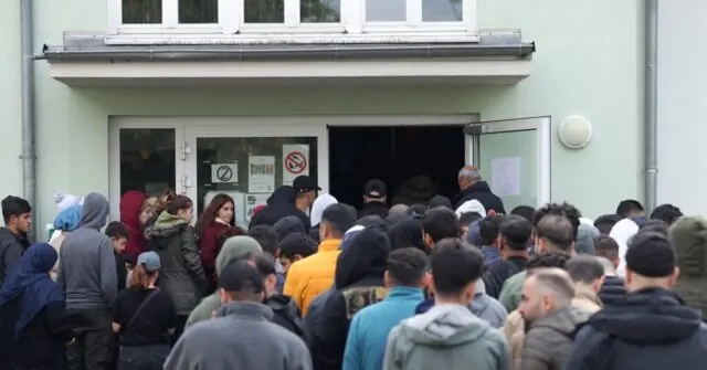 A large crowd of people gathers outside a building, possibly waiting for an event or service to begin.
