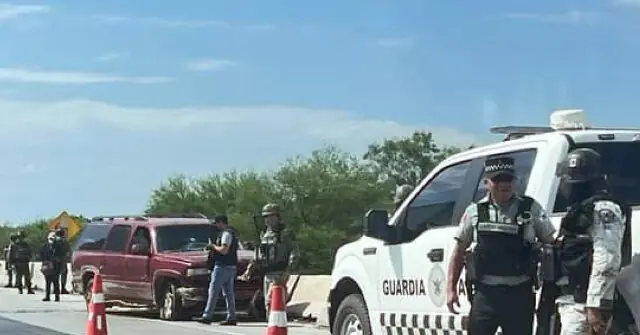 A group of law enforcement officers is seen at a roadside checkpoint, with one officer standing near a vehicle marked "Guardia."
