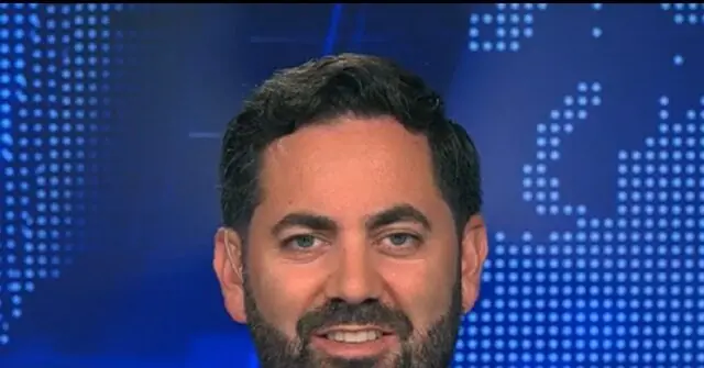 The image shows a person with a beard and short hair, set against a blue background with a dotted pattern.