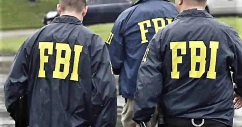 The image shows three FBI agents in uniform walking away from the camera.