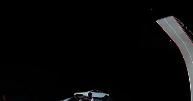 A futuristic white car is suspended in mid-air, seemingly defying gravity, with a dark background and a curved structure on the right.