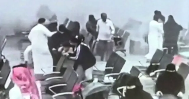 A group of people are gathered around a person lying on a stretcher, possibly in a medical or emergency situation.