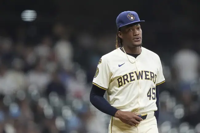 The image shows a baseball player wearing a Milwaukee Brewers uniform, standing on the field during a game.