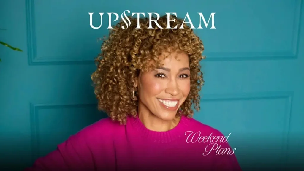 The image features a person with curly hair smiling, wearing a pink sweater, with the text "UPSTREAM" and "Weekend Plans" displayed above and below, respectively.