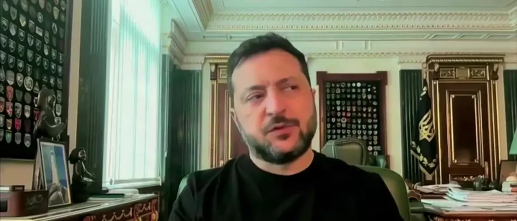 The image shows a person in a formal office setting, surrounded by decorative elements and framed pictures, suggesting a professional or official environment.