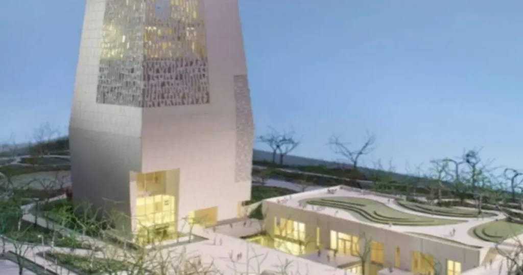 The image depicts a modern architectural design featuring a tall, intricate tower and a lower building with curved edges, surrounded by a landscaped area with trees.