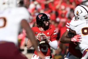 A football player in a red uniform prepares to throw the ball during a game.