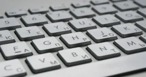 The image shows a close-up of a keyboard with Cyrillic and Latin characters, suggesting a dual-language input setup.