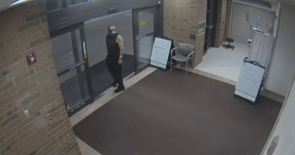 A person is seen entering a building through a glass door, with an "EXIT" sign visible nearby.