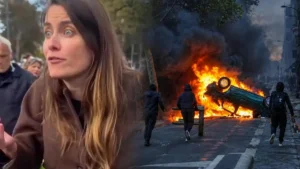 The image depicts a chaotic scene with a burning car and people running away, suggesting a protest or riot.