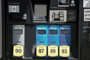 The image shows a gas pump display with various fuel options and their prices, including regular, plus, and premium gasoline.