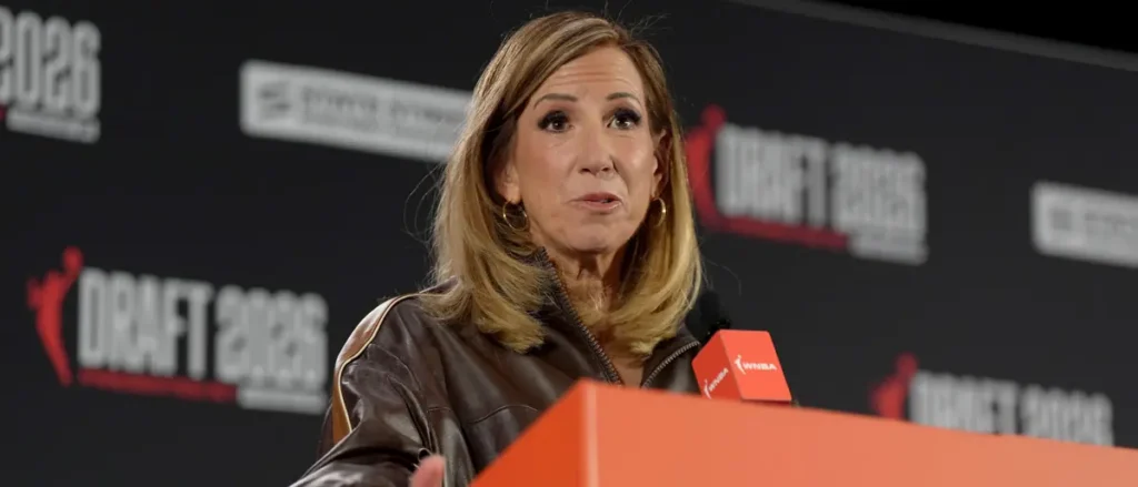 A woman speaks at a podium during a WNBA Draft event in 2026.