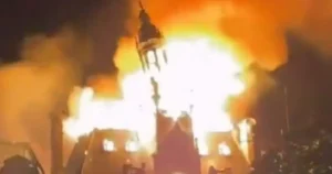 A building is engulfed in flames and smoke, indicating a severe fire incident.