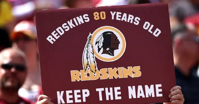 A sign supporting the Washington Redskins' name, celebrating 80 years of the team, is held up at a public event.