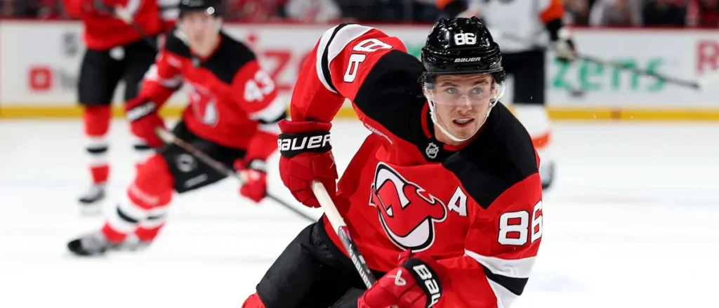 A hockey player in a red and black jersey, number 86, is in action on the ice during a game.