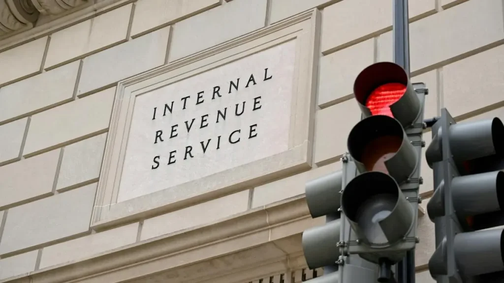 The image shows the Internal Revenue Service building with a traffic light in the foreground, symbolizing the intersection of tax law and everyday life.