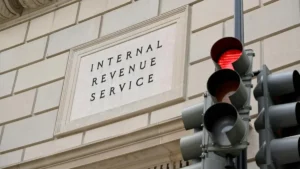 The image shows the Internal Revenue Service building with a traffic light in the foreground, symbolizing the intersection of tax law and everyday life.