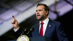 A man in a suit and tie is giving a speech at a podium with a U.S. presidential seal.