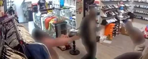 A security camera captures a scene inside a retail store, showing a customer interacting with a cashier at the checkout counter.