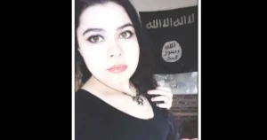 The image shows a person holding a flag with Arabic text, which is associated with a terrorist organization.