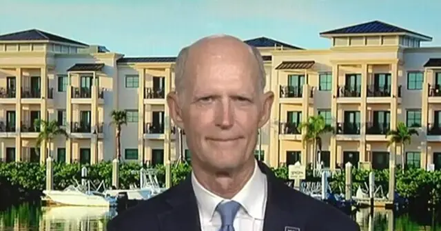 The news photo features a man in a suit standing in front of a waterfront residential building with palm trees and boats in the background.