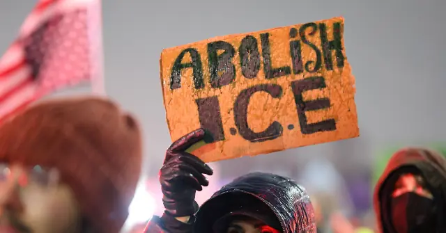 A protestor holds up a sign that reads "ABOLISH I.C.E." during a demonstration.