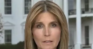 The image shows a news reporter in front of a white building with columns, likely a government or official building.