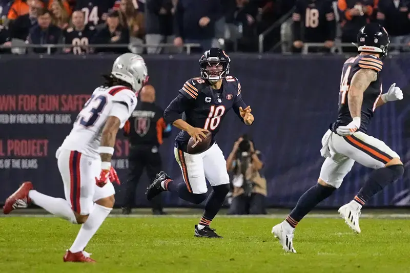 A Chicago Bears quarterback prepares to hand off the ball during a football game.