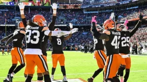 A group of Cleveland Browns players celebrate on the field during a football game.