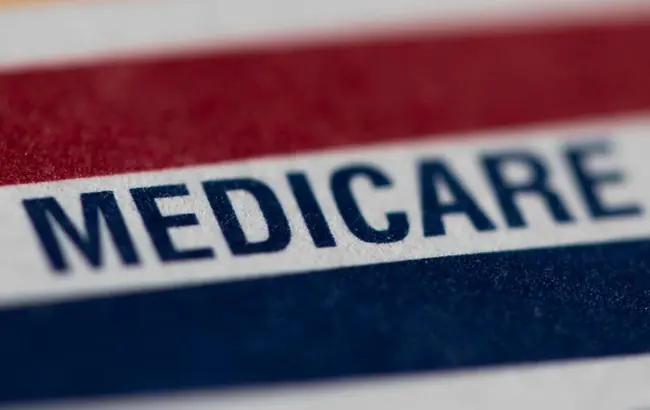 The image shows a close-up of a Medicare card with a red, white, and blue design.