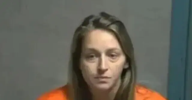 The image shows a person in an orange jumpsuit, likely in a law enforcement or correctional setting.